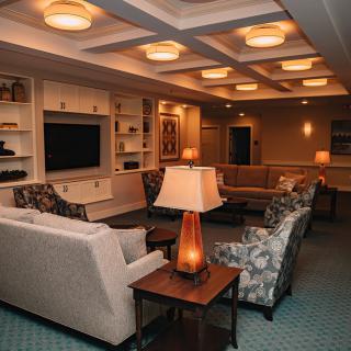 A cozy living room with sofas, a television, and ambient lighting.