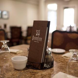 A neatly set dining table with a menu at a restaurant.
