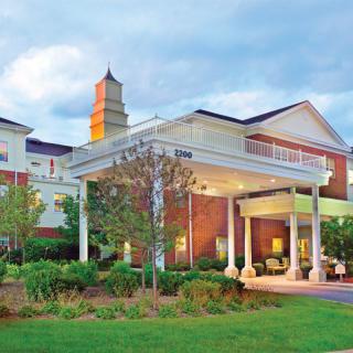 A beautifully designed building with a grand entrance and landscaped surroundings.