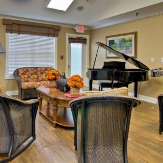 A cozy living room with comfortable seating and a grand piano.