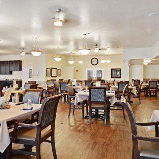 A spacious and well-lit dining area with neatly arranged tables and chairs.