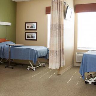 A hospital room with two beds separated by a curtain.