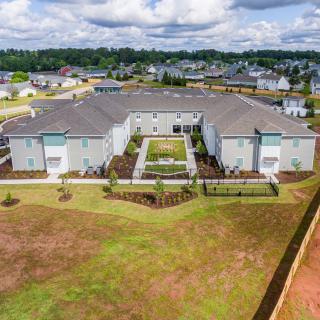Aerial view of a suburban residential building surrounded by green spaces.