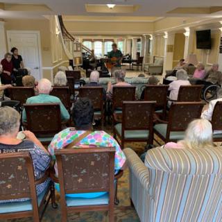 Residents of a senior living community enjoying a musical performance.