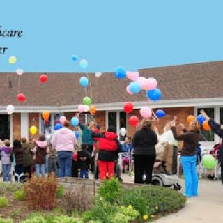 Community members celebrate together with colorful balloons at a local care center.