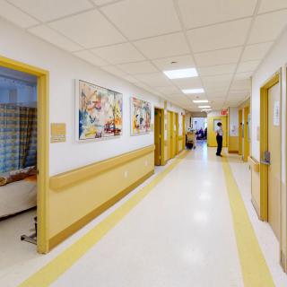 A clean and well-lit hospital corridor with doors on either side.