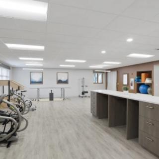A modern rehabilitation gym with stationary bikes and ample space, designed for exercise and therapy activities.