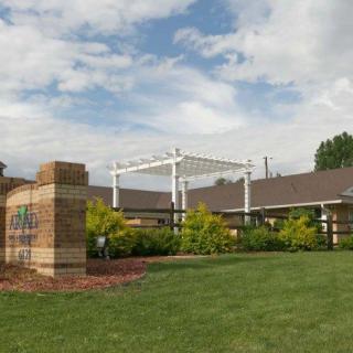 A building with a landscaped garden and a clear sky overhead.
