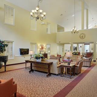 A spacious and elegantly designed lobby area with comfortable seating and a chandelier.