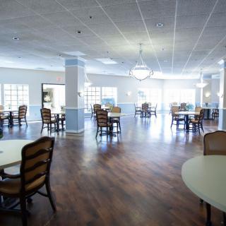 Spacious dining area with wooden floors and elegant lighting.