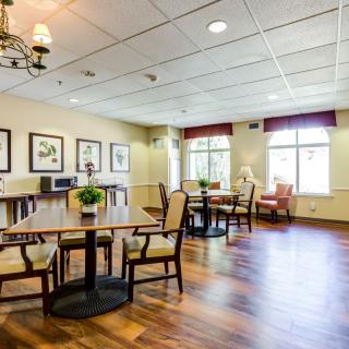 A bright and spacious dining area with tables, chairs, and decorative artwork on the walls.