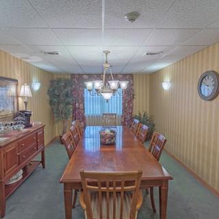 A cozy dining room with a wooden table and chairs, featuring a chandelier and warm decor.