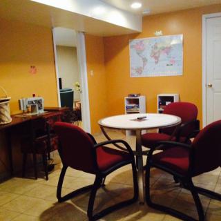 A cozy office meeting area with a round table, chairs, and a world map on the wall.
