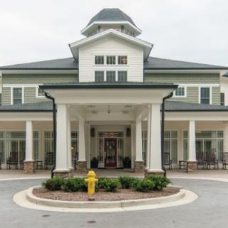 A grand building entrance with prominent columns and landscaped surroundings.