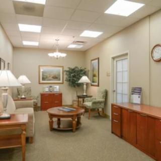 A well-lit office waiting room with comfortable seating and decor.