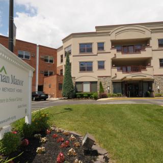 A hospital building with a sign and landscaped surroundings.