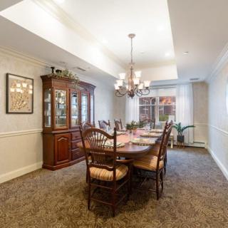 A well-furnished dining room with a large table and chandelier.