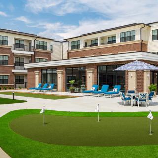 A modern apartment complex with outdoor amenities including a swimming pool and putting green.
