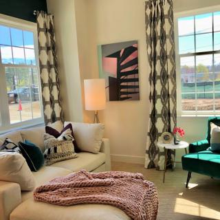 A cozy and modern living room with a comfortable sofa, stylish armchair, and large windows letting in natural light.