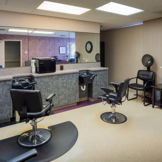 An empty hair salon with styling chairs and mirrors.