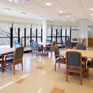 A well-lit interior space featuring tables and chairs, designed for collaborative activities.