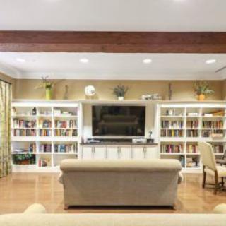 A cozy living room with bookshelves, a TV, and comfortable seating.