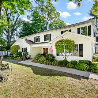 A charming suburban house with a well-maintained garden and lawn.