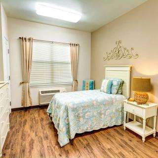 A cozy bedroom with a single bed, elegant curtains, and warm lighting.