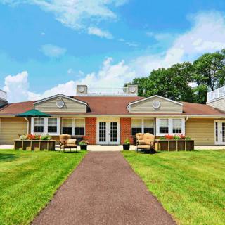 A suburban house with a well-maintained lawn and clear skies.