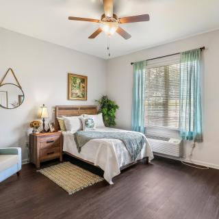 A modern bedroom with a bed, nightstand, and natural lighting from a window.