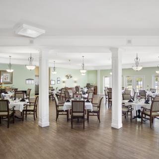 A spacious and elegantly decorated dining area with neatly arranged tables and chairs.