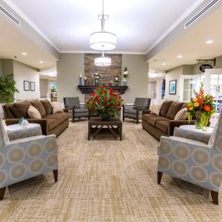 A spacious and elegantly decorated living room with comfortable seating and floral arrangements.