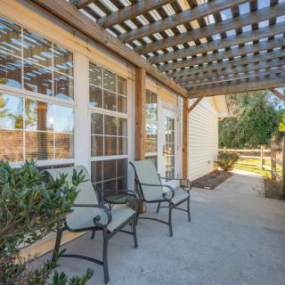 A cozy outdoor patio with chairs under a pergola.
