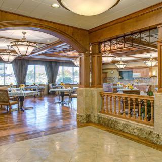 Elegant dining area with wooden accents and chandeliers.