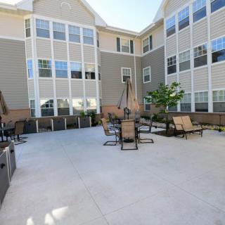 A spacious outdoor patio area with seating at a modern apartment complex.