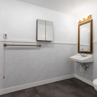 A modern bathroom featuring a stylish sink, a large mirror, and elegant lighting.
