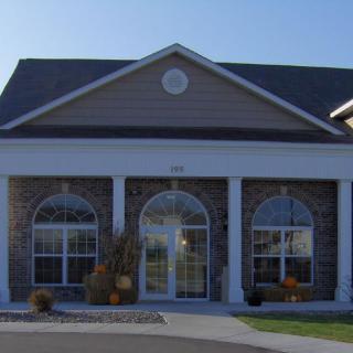 Front view of a residential building with large windows and an arched entrance.
