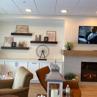 A cozy, modern living room featuring stylish furniture, decorative shelves, and a warm fireplace.