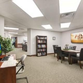 A professional office space with desks, chairs, and a bookshelf.