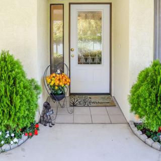 A welcoming front entrance with potted plants and flowers.
