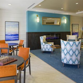 A modern lounge area featuring patterned chairs, tables, and stylish decor.