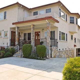 A suburban two-story house with a driveway and landscaped entrance.