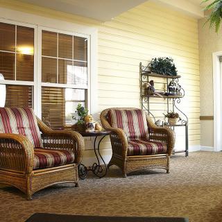 A cozy sitting area with wicker chairs and decorative shelving.
