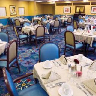 An elegant restaurant dining room with tables set for service.