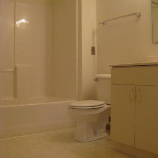 A clean and simple bathroom with a bathtub, toilet, and sink.