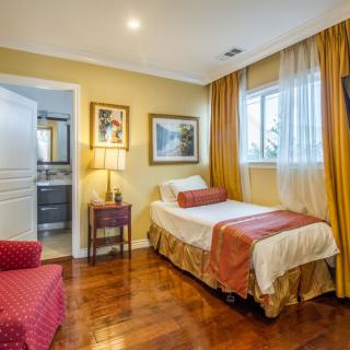 A cozy bedroom with a single bed, warm lighting, and elegant decor.