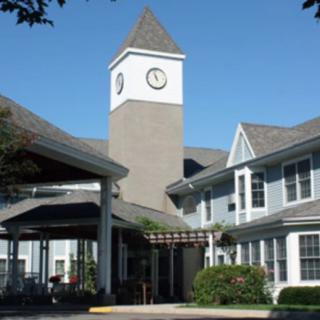 A residential building with a clock tower on a clear day.