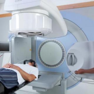 A patient undergoing treatment with a radiotherapy machine in a medical facility.