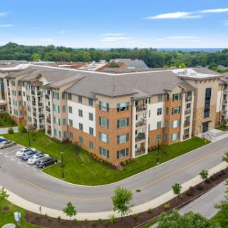 Aerial view of a modern residential apartment complex surrounded by greenery.