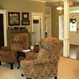 Traditional living room with armchairs, a fireplace, and framed pictures.